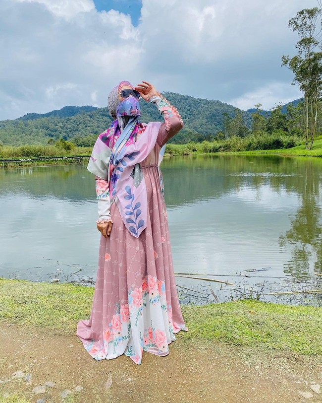 Kala piknik di alam terbuka, April Jasmine konsisten dengan gaya stylish-nya. Seperti di foto ini, ia dibungkus terusan bermotif floral yang feminin dipadu dengan hijab panjang senada. (Foto: Instagram/@apriljasmine28)