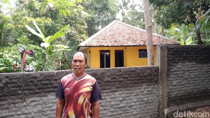 Muslih warga Desa Karangbenda, Kecamatan Parigi, Kabupaten Pangandaran berfoto di rumahnya yang tertutup benteng.