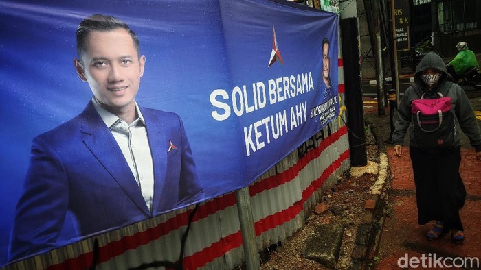 Warga melintas di depan spanduk dukungan untuk Ketum Partai Demokrat Agus Harimurti Yudhoyono, di jalan Fatmawati, Jakarta Selatan, Sabtu (3/4/2021). Spanduk dukungan tersebut terlihat di beberapa titik strategis di Jakarta. Seperti diketahui, sekelompok orang membuat acara yang disebut KLB Partai Demokrat dan memilih Moeldoko sebagai Ketua Umum, beberapa waktu lalu.