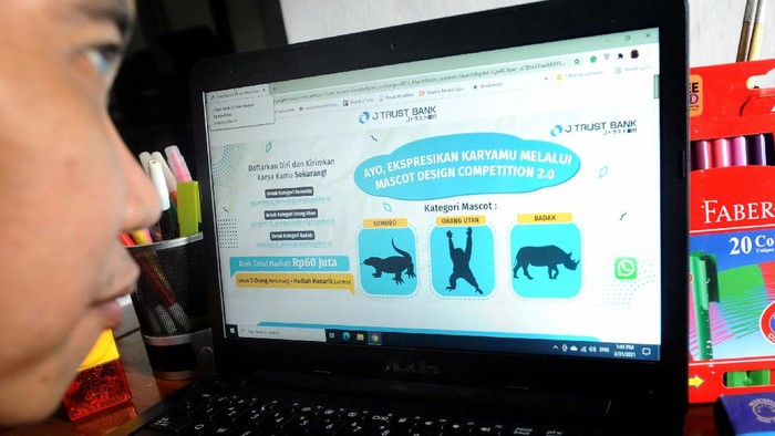 Lomba Desain Maskot J Trust Bank Seorang perancang grafis mengamati pengumuman kompetisi maskot yang digelar PT Bank J Trust Indonesia Tbk (J Trust Bank) di Jakarta, Minggu (4/4/2021). Lebih dari 1.000 perancang grafis telah mendaftar untuk mengikuti lomba pembuatan maskot dengan tema hewan langka di Indonesia, sebagai komitmen J Trust Bank dalam mendukung tumbuhnya industri kreatif di masa pandemi.