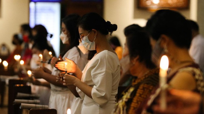 Umat Kristiani melaksanakan Misa Malam Paskah di Gereja Katolik Kristus Raja, Surabaya, Jawa Timur, Sabtu (3/4/2021). Ibadah rangkaian Perayaan Paskah tersebut digelar dengan tetap menerapkan protokol kesehatan. ANTARA FOTO/Didik Suhartono/rwa.