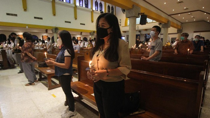 Umat Kristiani melaksanakan Misa Malam Paskah di Gereja Katolik Kristus Raja, Surabaya, Jawa Timur, Sabtu (3/4/2021). Ibadah rangkaian Perayaan Paskah tersebut digelar dengan tetap menerapkan protokol kesehatan. ANTARA FOTO/Didik Suhartono/rwa.