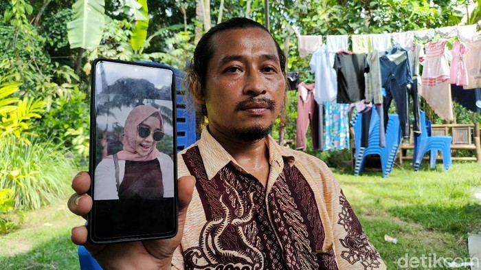 Sunardi menunjukkan foto sang adik Takdir Sunariati, semasa hidup, Minggu (4/4/2021).