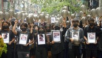Pengunjuk rasa anti-kudeta memegang foto orang-orang yang tewas dalam protes terhadap militer di Yangon, Myanmar, Senin (5/4/2021) waktu setempat.