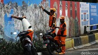 Sejumlah petugas PPSU melakukan bersih-bersih dinding mural yang berada di Jalan KH Abdullah Syafei, Tebet, Jakarta Timur, Senin (05/04/2021).