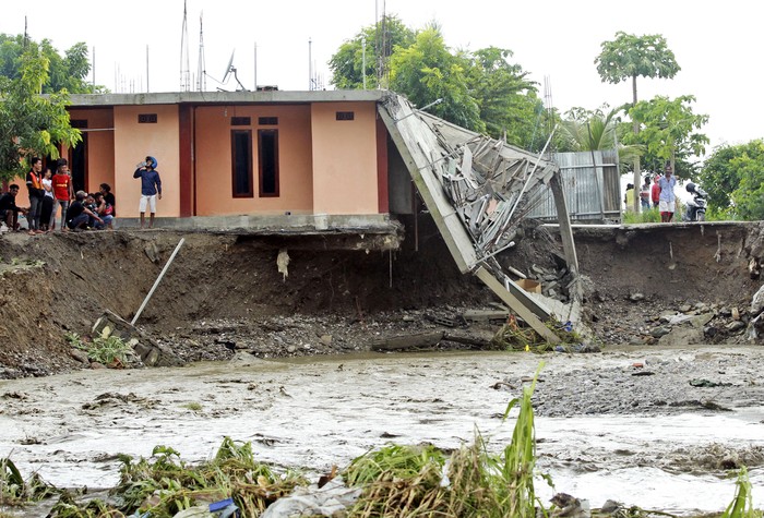 People walk amid debris at a village affected by flood in Ile Ape, on Lembata Island, East Nusa Tenggara province, Indonesia, Sunday, April 4, 2021 photo. Multiple disasters caused by torrential rains in eastern Indonesia have left dozens of people dead or missing while displacing thousands, the countrys disaster relief agency said Monday.