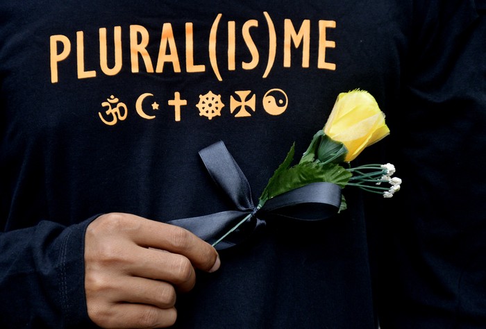 Peserta aksi yang tergabung dalam Forum Rakyat Bersatu memegang bunga saat melakukan aksi solidaritas di depan Gereja Katedral, Makassar, Sulawesi Selatan, Minggu (4/4/2021). Aksi yang digelar dari berbagai elemen mahasiswa, tokoh agama, serta masyarakat tersebut sebagai aksi solidaritas kerukunan beragama guna mengajak seluruh masyarakat Indonesia untuk tetap solid dan mendeklarasikan diri untuk melawan aksi terorisme. ANTARA FOTO/Abriawan Abhe/foc.