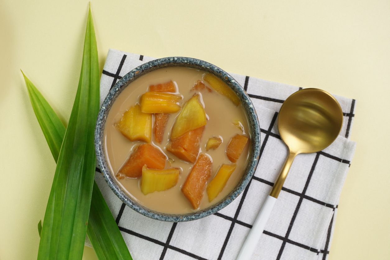 Kolak Ubi Nangka, Indonesian dessert, made from Sweet potato and Jack fruit cooked with palm sugar, coconut milk, pandanus leaves. Very popular during Ramadhan. Clean Yellow background