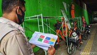 Petugas melihat desain mural yang akan dibuat di kolong tol Jl Bintaro Permai Raya, Jakarta Selatan.