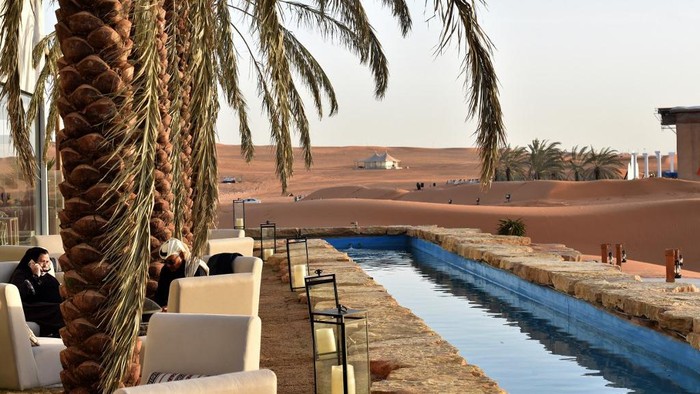 The Riyadh Oasis Visitors relax in a lounge area beneath palm trees at the