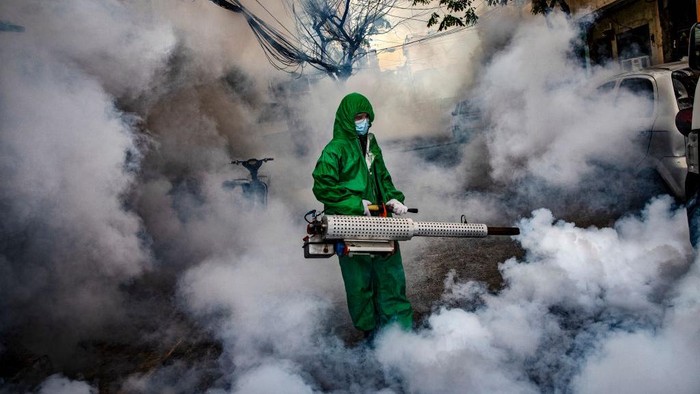 1231940432 MANILA, PHILIPPINES - A worker wearing a hazmat suit uses a fogging machine to disinfect a street as preventive measure against COVID-19 in Manila, Philippines. Curfews and stricter lockdowns are being implemented in several areas across the Philippines as the country experiences its worst surge in cases since the lockdown began more than a year ago. The country has reported more than 693,000 cases of COVID-19 so far, with at least 13,095 deaths. (Photo by Ezra Acayan/Getty Images)