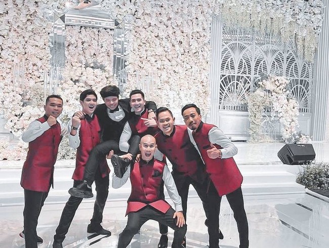 Al, Verrell, dan lima teman dekat Atta Halilintar lainnya yang diminta untuk menjadi groomsmen kompak berseragam. Hampir semua groomsmen terlihat memakai kemeja putih dan celana hitam yang dibalut dengan vest merah. Sayangnya beberapa netizen nyinyir dengan model seragam itu yang dibilang mirip baju cleaning service, pelayan restoran hingga petugas katering. Foto: Instagram @bramastavrl