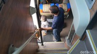 Tangga bus eksekutif DD Garuda Mas. Di samping bawah tangga ada toilet. Beberapa tempat sampah ada sekitar area ini.
