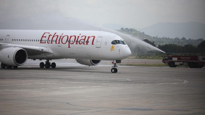 Disinfectant workers spray disinfectant on an Ethiopian Airlines plane arriving at the Nnamdi Azikiwe International Airport, in Abuja, Nigeria on September 7, 2020. - After a five-month closure of the Nigerian airspace due to the COVID-19 coronavirus pandemic, flight resumptions began in Abuja, Nigeria. (Photo by Kola Sulaimon / AFP)