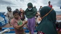 Warga mengevakuasi seorang ibu hamil dari kawasan terdampak banjir bandang.