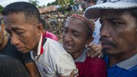 Sejumlah warga menangisi kerabatnya yang ditemukan meninggal dunia akibat banjir bandang.