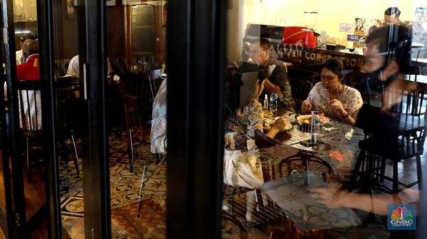 Petugas membersihkan meja makanan di Restoran di Kawasan Benhil, Jakarta, Selasa 6/4. Perhimpunan Hotel dan Restoran Indonesia (PHRI) Jakarta ingin pemerintah meningkatkan kapasitas jumlah pengunjung yang bisa makan di tempat alias dine in di tempat makan menjadi 75 persen saat masa buka bersama (bukber) puasa sepanjang Ramadan. Saat ini, kapasitas pengunjung dine in hanya boleh 50 persen. Kebijakan ini diterapkan karena pemerintah masih melangsungkan Pemberlakuan Pembatasan Kegiatan Masyarakat (PPKM) Mikro. Terkait hal ini, Pelaksana Tugas (Plt) Kepala Dinas Pariwisata dan Ekonomi Kreatif DKI Jakarta Gumilar Ekalaya mengatakan belum ada perubahan aturan terkait kapasitas jam operasional restoran saat momen buka puasa bersama seperti dikutip CNN Indonesia. Namun, pemerintah tetap membuka masukan dari pengusaha. Pelaksana tugas (Plt) Kepala Dinas Pariwisata dan Ekonomi Kreatif DKI Jakarta, Gumilar Ekalaya juga mengatakan pihaknya tidak melarang pelaksanaan kegiatan buka puasa bersama (bukber) di restoran atau rumah makan di masa pandemi Covid-19. Menurut Gumilar, waktu pelaksanaan kegiatan bukber tidak melanggar ketentuan dalam PPKM Mikro. Meski tidak melarang, Gumilar mengingatkan kegiatan buka bersama harus tetap menerapkan protokol kesehatan. (CNBC Indonesia/Muhammad Sabki)