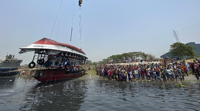 Kapal Feri di Bangladesh Tenggelam, 26 Orang Tewas Rescuers recover bodies after a ferry sank Sunday night after being hit by a cargo vessel in the Shitalakkhya River in Narayanganj district, outside Dhaka, Bangladesh, Monday, April 5, 2021. (AP Photo/Mushfiqul Alam)
