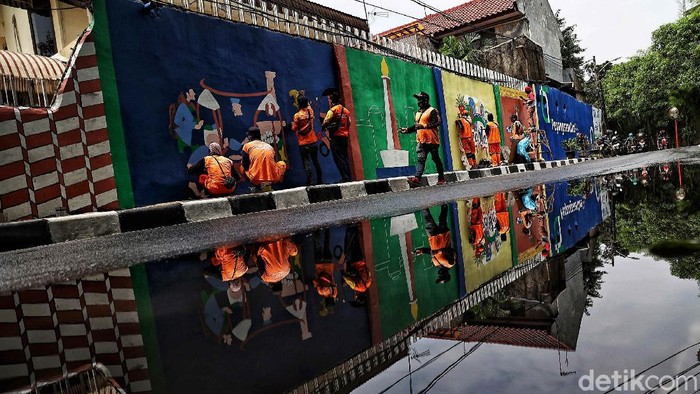 Mural Jakarta Kolaborasi Sejunlah petugas PPSU membuat Mural dengan tema Jakarta Kolaborasi di kawasan, Pengangsaan Dua, Jakarta Utara, Senin (5/4).