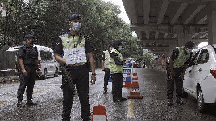 KUALA LUMPUR, MALAYSIA - MARCH 21: Members of Malaysian Royal Police Force check on vehicles at a road block in a residential neighbourhood on March 21, 2020 in Kuala Lumpur, Malaysia. Malaysian police have set up more than 500 roadblocks as Malaysias lockdown enters its 4th day. The measures were introduced in an attempt to stop the spread of coronavirus (COVID-19). (Photo by Rahman Roslan/Getty Images)