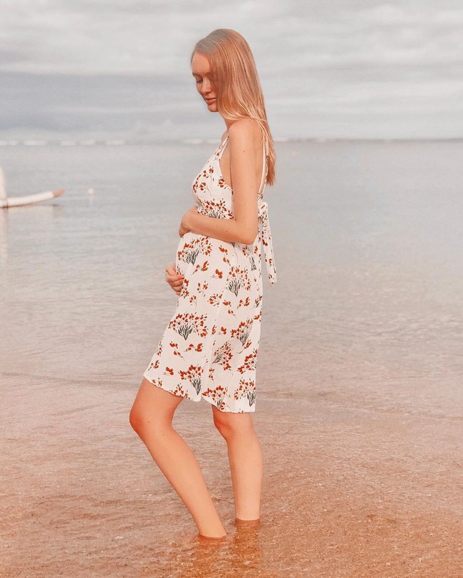 Polly Alexandria yang berusia 24 tahun itu tampil memesona ketika memakai dress putih motif floral di salah satu pantai di Bali.  Foto: Dok. Instagram @pollyoddsocks.