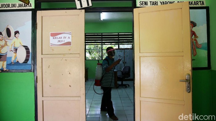 Guru menyiapkan ruang kelas di SD Kenari 08 Pagi di, Jakarta Pusat, Selasa (6/4/2021). Proses pembersihan kelas ini dilakukan guna mempersiapakan uji coba kegiatan belajar tatap muka yang akan diselenggarakan 7-29 April 2021.