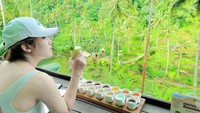 Momen kulineran Via Vallen juga semakin seru karena dilakukan di tengah-tengah waktu traveling. Momen tersebut diabadikan lewat foto yang satu ini. Via menikmati minuman dengan pemandangan pepohonan. Foto: Instagram @viavallen