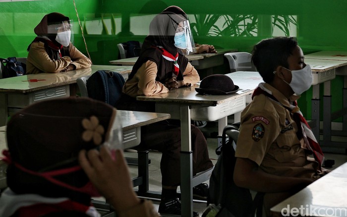 Guru memberikan pelajaran kepada murid saat uji coba belajar tatap muka di kawasan SDN 11 Pademangan Barat, Jakarta Utara, Rabu (7/4). SDN Pademangan Barat 11 memulai uji coba belajar tatap muka bagi siswa kelas V di tengah pandem COVID-19. Protokol kesehatan menjadi hal utama baik bagi siswa maupun tenaga pendidik.
