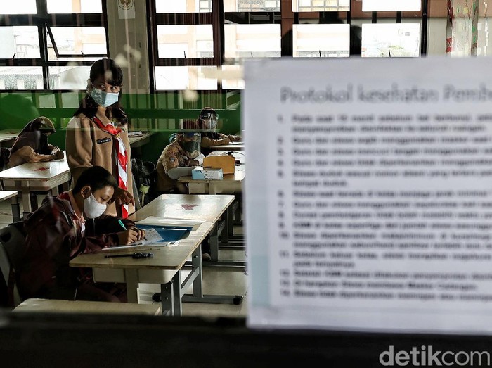 Guru memberikan pelajaran kepada murid saat uji coba belajar tatap muka di kawasan SDN 11 Pademangan Barat, Jakarta Utara, Rabu (7/4). SDN Pademangan Barat 11 memulai uji coba belajar tatap muka bagi siswa kelas V di tengah pandem COVID-19. Protokol kesehatan menjadi hal utama baik bagi siswa maupun tenaga pendidik.