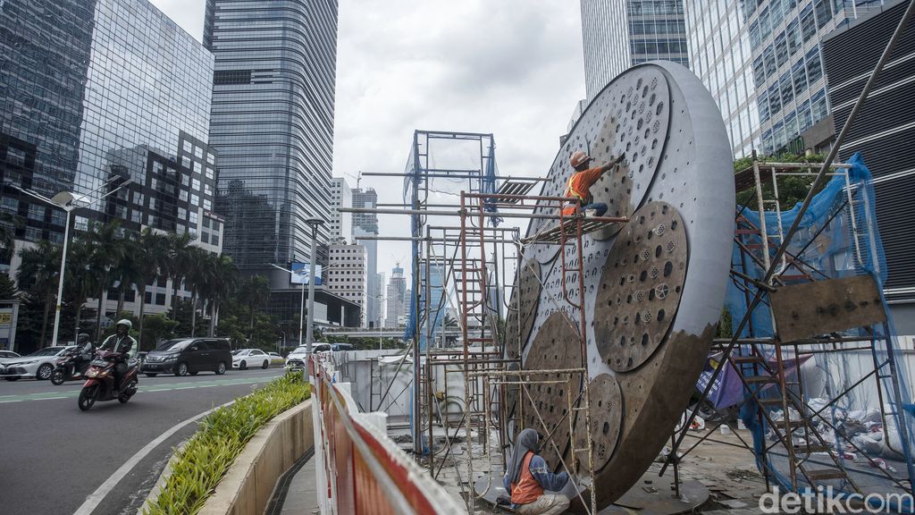 Pekerja menyelesaikan pembangunan Tugu Sepeda di Jalan Jenderal Sudirman, Jakarta, Senin (7/4/2021). Pembangunan tugu yang berbentuk satu buah ban sepeda berukuran raksasa tersebut sebagai pengingat momentum penggunaan sepeda yang masif digunakan masyarakat Ibu Kota di tengah pandemi COVID-19.