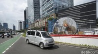 Sebuah kendaraan melewati proyek pembangunan Tugu Sepeda di jalan Jenderal Sudirman. 