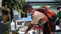 Para siswa yang datang diharuskan mencuci tangan terlebih dahulu.
