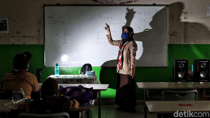 Wajah-wajah Melepas Rindu Belajar di Sekolah Guru memberikan pelajaran kepada murid saat uji coba belajar tatap muka di kawasan SDN 11 Pademangan Barat, Jakarta Utara, Rabu (7/4). SDN Pademangan Barat 11 memulai uji coba belajar tatap muka bagi siswa kelas V di tengah pandem COVID-19. Protokol kesehatan menjadi hal utama baik bagi siswa maupun tenaga pendidik.