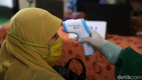 Para guru dicek suhu tubuhnya sebelum mengikuti vaksinasi COVID-19.