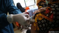 Petugas menyuntikan vaksin di lengan kiri para guru. 
