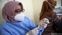 Petugas kesehatan bersiap memberikan suntikan vaksin kepada tenaga pengajar atau guru.