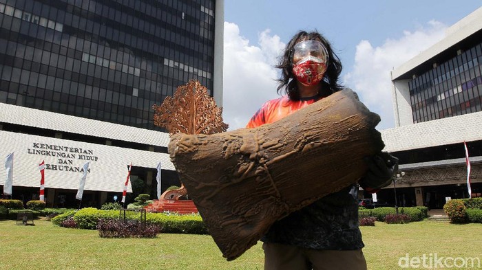 Bawa Bonggol Pohon, Greenpeace Demo Tolak Pengrusakan Hutan Aktivis Greenpeace menggelar aksi unjuk rasa menolak perusakan hutan Papua di halaman Kantor Kementerian Lingkungan Hidup dan Kehutanan, Jakarta, Kamis (8/4/2021). Greenpeace menuntut pemerintah menindaklanjuti temuan dugaan pelanggaran penerbitan izin pelepasan hutan di Papua, serta melakukan corrective action sehingga tutupan hutan yang masih ada di dalam areal perkebunan yang belum dirusak bisa dikembalikan kepada masyarakat adat Papua.