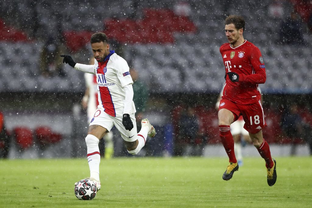 PSG's Neymar, left, prepares to take a shot as Bayern's Leon Goretzka runs behind him during the Champions League quarterfinal soccer match between Bayern Munich and Paris Saint Germain in Munich, Germany, Wednesday, April 7, 2021. (AP Photo/Matthias Schrader)