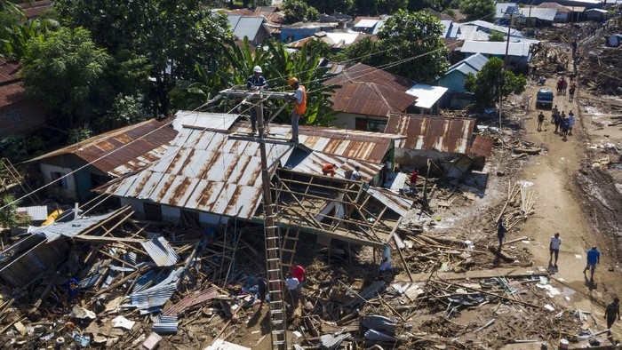 Sejumlah petugas memperbaiki jaringan listrik yang terputus akibat banjir bandang di Adonara Timur, Kabupaten Flores Timur, Nusa Tenggara Timur (NTT), Kamis (8/4/2021). Pemulihan infrastruktur dilakukan untuk kembali menghidupkan perekonomian masyarakat setempat pascabencana alam yang terjadi pada Minggu (4/4) tersebut. ANTARA FOTO/Aditya Pradana Putra/rwa.