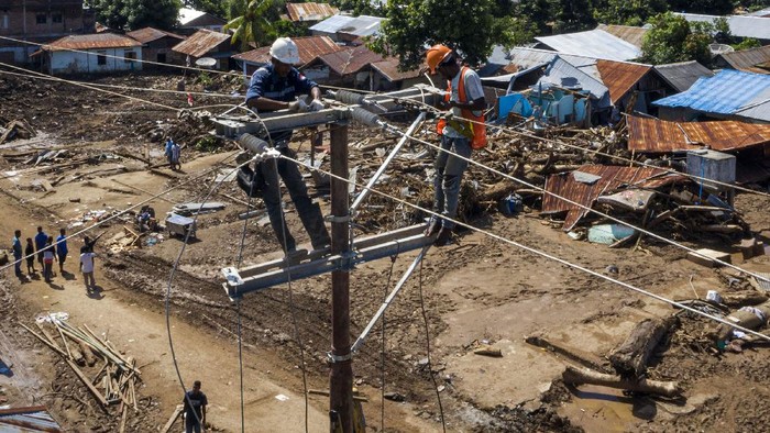 Sejumlah petugas memperbaiki jaringan listrik yang terputus akibat banjir bandang di Adonara Timur, Kabupaten Flores Timur, Nusa Tenggara Timur (NTT), Kamis (8/4/2021). Pemulihan infrastruktur dilakukan untuk kembali menghidupkan perekonomian masyarakat setempat pascabencana alam yang terjadi pada Minggu (4/4) tersebut. ANTARA FOTO/Aditya Pradana Putra/rwa.