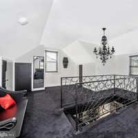 Sementara di lantai atas rumah, lantainya terlihat dilapisi dengan karpet berwarna gelap. Lampu gantung hitam bernuansa vintage juga tampak menghiasi lantai atas rumah tersebut. Foto: realtor.com