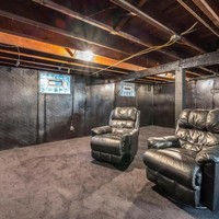 Rumah ini juga memiliki ruang bawah tanah. Ruang bawah tanahnya didominasi dengan warna hitam. Terdapat dua buah sofa kulit berwarna hitam yang diletakkann di depan TV. Foto: realtor.com