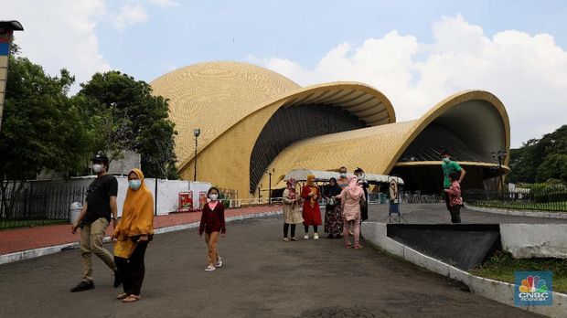 Pengunjung berjalan di depan taman legenda di TMII, Jakarta, Kamis (8/4/2021). Pemerintah melalui Kementerian Sekretariat Negara (Kemensetneg) menyampaikan pengambilalihan Taman Mini Indonesia Indah (TMII) yang selama ini dikuasai Yayasan Harapan Kita milik keluarga mantan Presiden Suharto. TMII merupakan aset negara dan mulai tahun ini, pengelolaan aset negara itu diambil alih Kemensetneg. Mensesneg Pratikno menjelaskan, TMII sebelumnya dikelola selama hampir 44 tahun oleh Yayasan Harapan Kita. Untuk diketahui Yayasan Harapan Kita didirikan oleh istri Presiden RI ke-2 Soeharto, Tien Soeharto (CNBC Indonesia/ Muhammad Sabki)