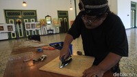 Sardi terlihat asyik membuat wayang.