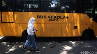 Seorang siswa SMK Negeri 15 Jakarta Selatan melintas di depan bus sekolah.