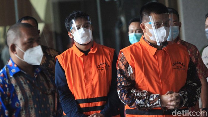 Tersangka kasus dugaan korupsi pengadaan barang COVID-19, Bupati Bandung Barat Aa Umbara Sutisna dan anaknya, Andri Birawa mengenakan rompi tahanan dengan tangan terborgol di di Gedung KPK Jakarta, Jumat (9/4/2021. Keduanya ditahan KPK dalam perkara dugaan suap terkait pengadaan barang tanggap darurat bencana pandemi COVID-19. Aa Umbara diduga menerima suap Rp 1 miliar terkait kasus ini.