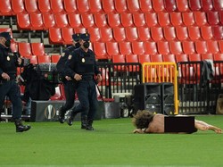 Pria bugil tersebut berlari-lari dan langsung rebahan di lapangan. (Foto: Cristina Quicler/AFP/Edit)