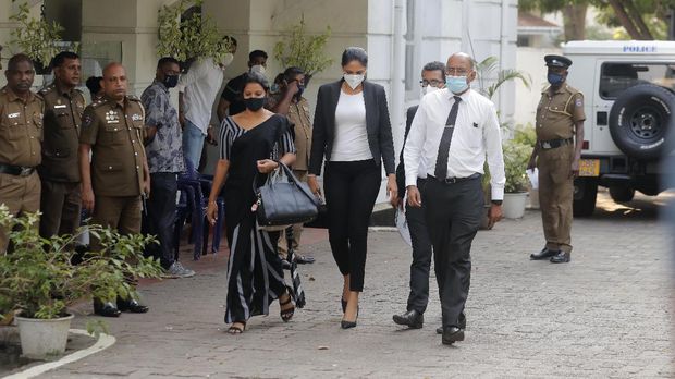 Mrs. World 2019 Caroline Jurie, center, leaves a police station after obtaining bail in Colombo, Sri Lanka, Thursday, April 8, 2021. Jurie's decision to remove the crown from the the winning Mrs. Sri Lanka contestant on stage moments after the winner was announced, because of claims she was a divorcee, drew widespread social media condemnation.  The winner Pushpika de Silva who was crowned again later had complained to police that her head was wounded when the clips of her crown were removed by Jurie. (AP Photo/Eranga Jayawardena)