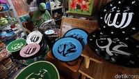 Perajin menggambar seni kaligrafi di permukaan piring di rumahnya, Pasar Kliwon, Solo, Jawa Tengah, Kamis (8/4).