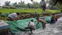 Sejumlah warga bergotong royong membilas karpet mushalla usai dicuci di Karanganyar, Kabupaten Pekalongan, Jawa Tengah, Jumat (9/4/2021).